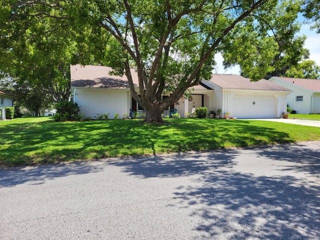 ranch-style home with a garage and a front yard