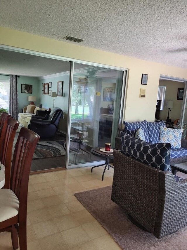 living room with visible vents, a textured ceiling, and tile patterned floors