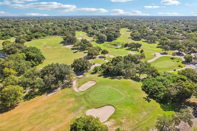 aerial view with golf course view and a wooded view