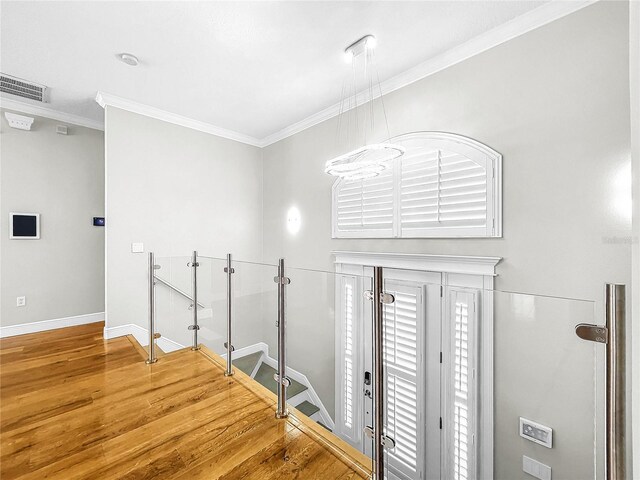 entrance foyer with crown molding and wood-type flooring