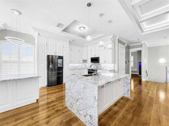 kitchen with sink, ornamental molding, stainless steel appliances, light stone countertops, and white cabinets