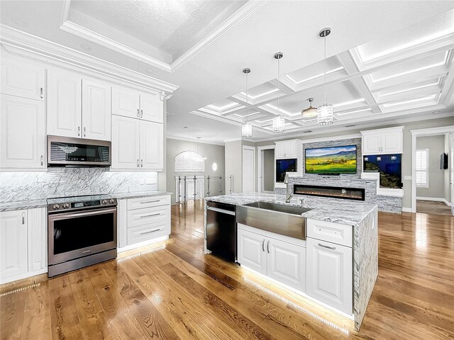 kitchen with crown molding, pendant lighting, stainless steel appliances, light hardwood / wood-style floors, and white cabinets