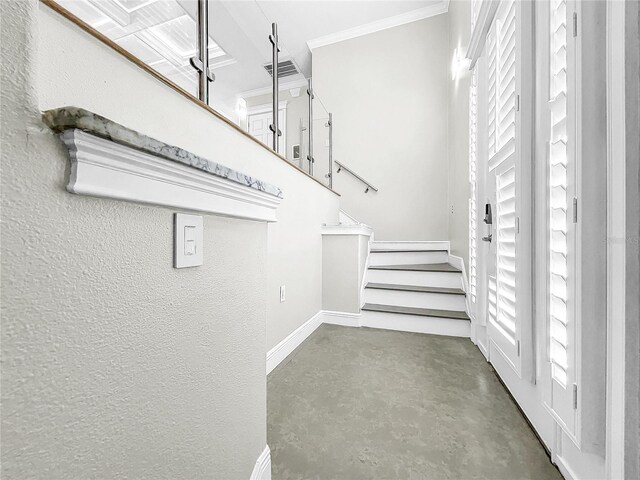 staircase featuring crown molding and concrete flooring