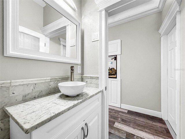 bathroom with vanity, wood-type flooring, and ornamental molding