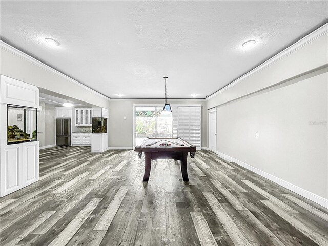 game room with billiards, dark wood-type flooring, ornamental molding, and a textured ceiling