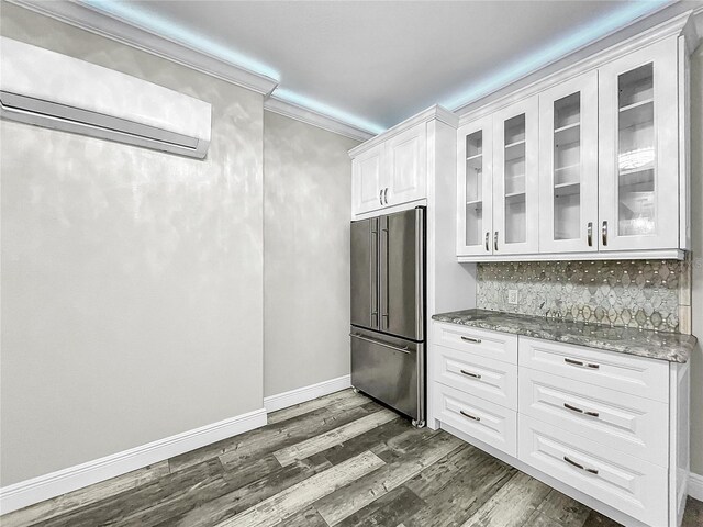 kitchen featuring dark hardwood / wood-style floors, white cabinetry, light stone counters, crown molding, and high end fridge