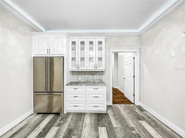 kitchen with crown molding, dark hardwood / wood-style floors, light stone countertops, white cabinets, and high end refrigerator