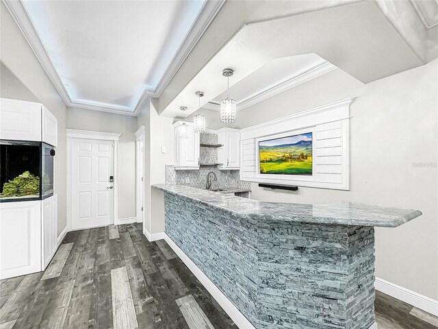 bar with crown molding, dark wood-type flooring, pendant lighting, and white cabinets