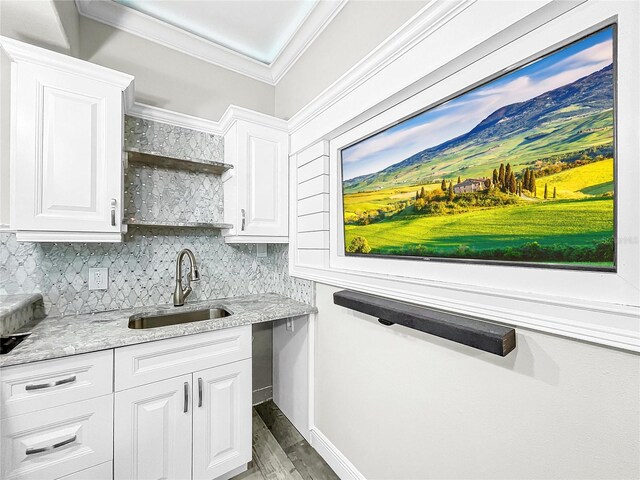 kitchen featuring white cabinetry, sink, crown molding, and light stone counters