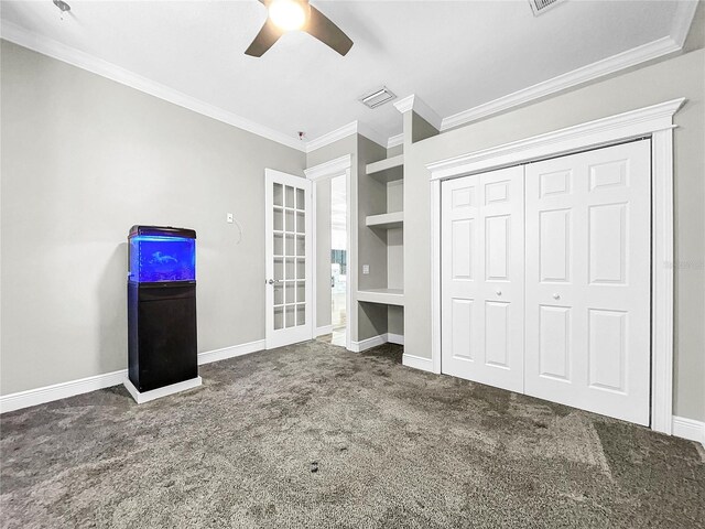 unfurnished bedroom with ceiling fan, a closet, ornamental molding, and carpet