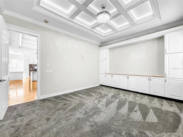 carpeted spare room featuring beamed ceiling, ornamental molding, and coffered ceiling