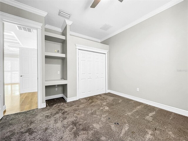 unfurnished bedroom with ceiling fan, ornamental molding, dark carpet, and a closet