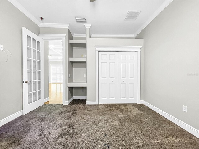 unfurnished bedroom featuring ornamental molding, a closet, and dark colored carpet