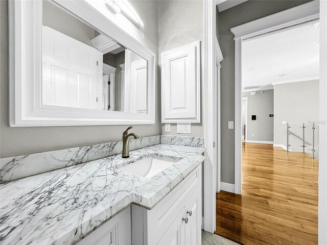 bathroom featuring vanity, hardwood / wood-style flooring, and ornamental molding