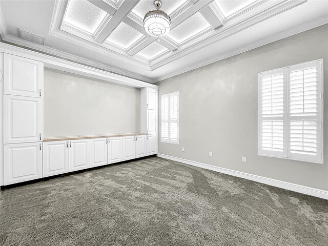 empty room with coffered ceiling, ornamental molding, and carpet