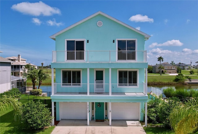 coastal inspired home featuring a balcony, a garage, and a front lawn