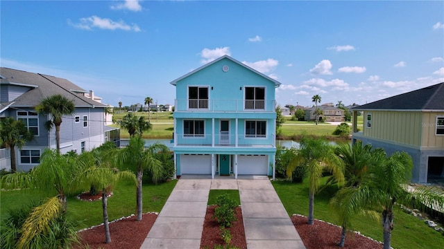 view of front facade featuring a garage, a front yard, and a balcony