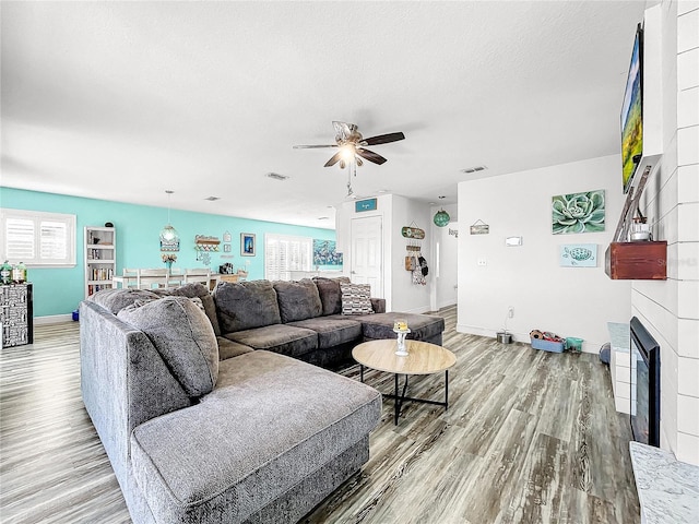 living room with ceiling fan, hardwood / wood-style floors, and a textured ceiling