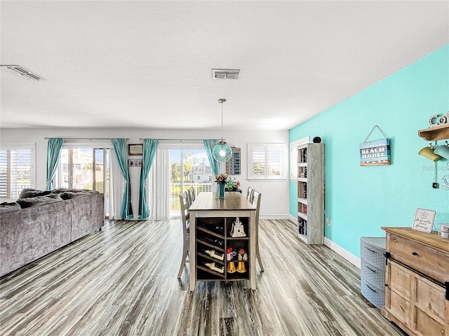 dining area with hardwood / wood-style floors and a textured ceiling