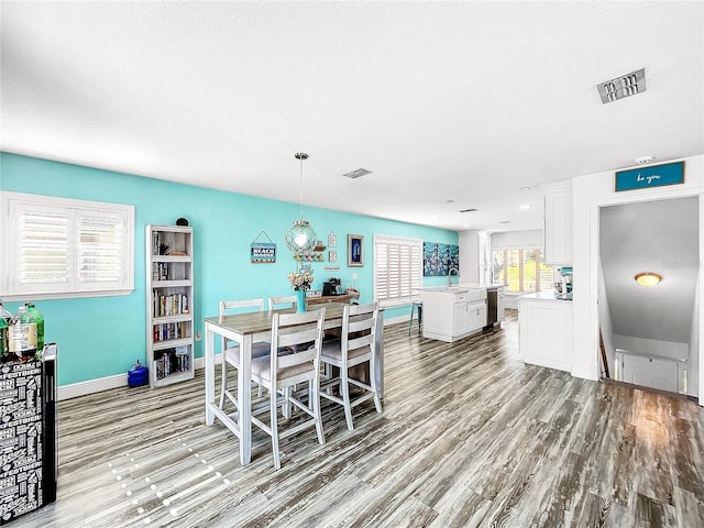 dining area with sink, light hardwood / wood-style flooring, and a textured ceiling