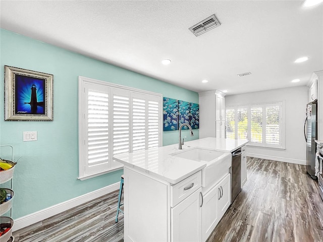 kitchen featuring sink, a kitchen island with sink, stainless steel appliances, white cabinets, and dark hardwood / wood-style flooring