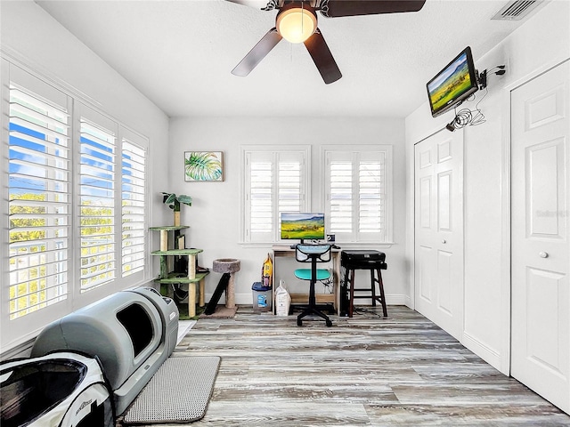 home office with ceiling fan and light wood-type flooring