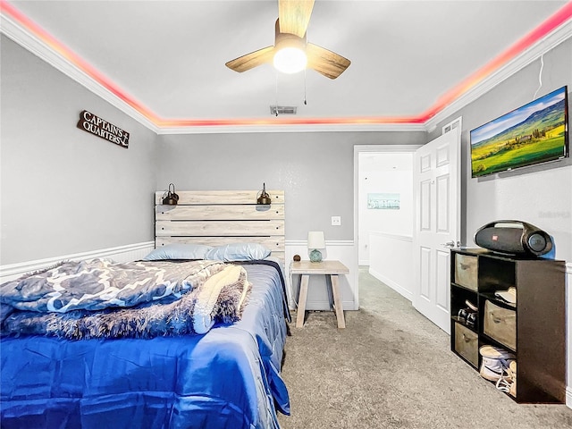 carpeted bedroom with ornamental molding and ceiling fan