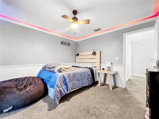 carpeted bedroom with ornamental molding and ceiling fan