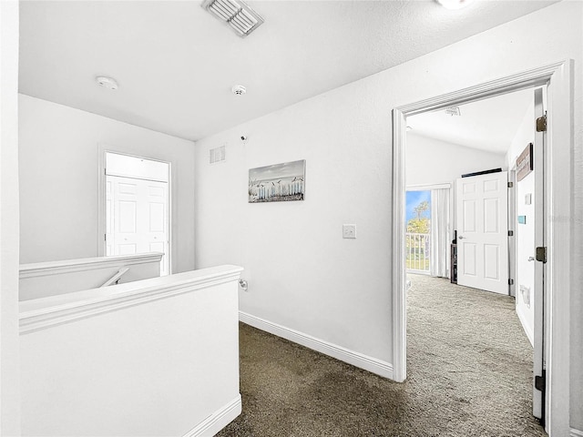 unfurnished bedroom with vaulted ceiling and dark colored carpet