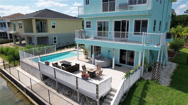 rear view of house featuring a fenced in pool and a patio area