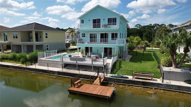 back of house featuring a patio area, a balcony, and a water view