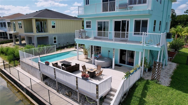 rear view of house featuring a fenced in pool and a patio