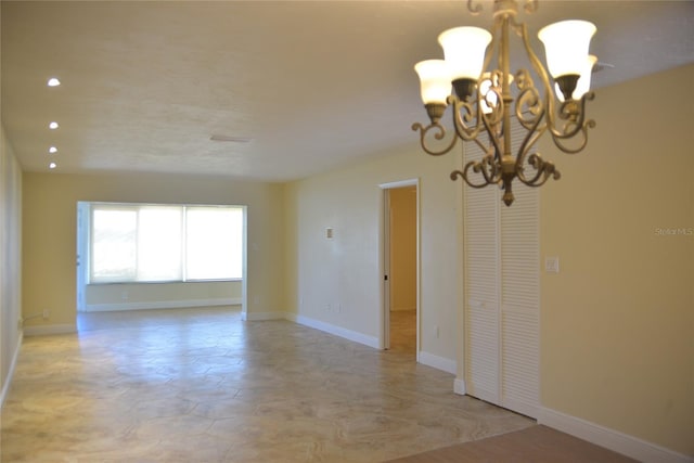 empty room featuring light tile patterned flooring and a chandelier