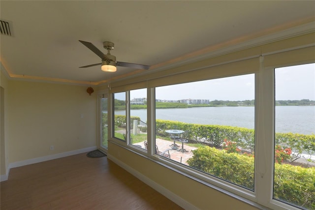 unfurnished sunroom featuring a water view and ceiling fan