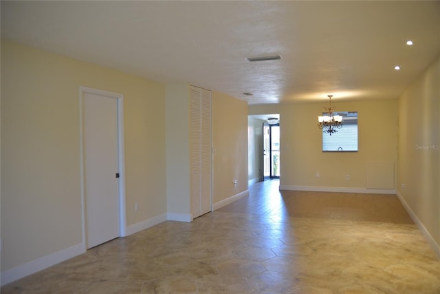 unfurnished room with an inviting chandelier