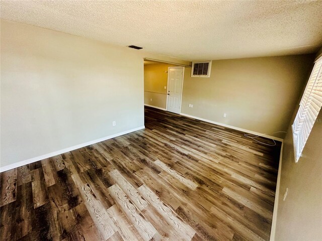 spare room featuring hardwood / wood-style flooring and a textured ceiling