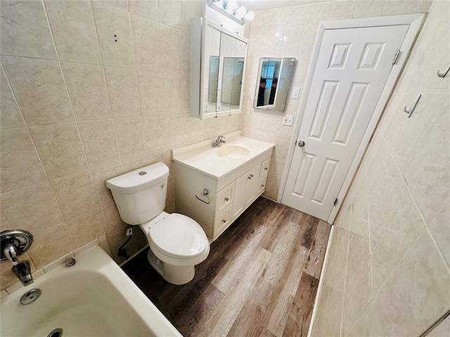 bathroom featuring toilet, vanity, hardwood / wood-style flooring, and tile walls