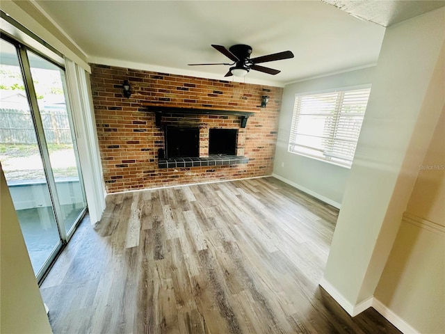 unfurnished living room featuring a fireplace, hardwood / wood-style flooring, and ceiling fan