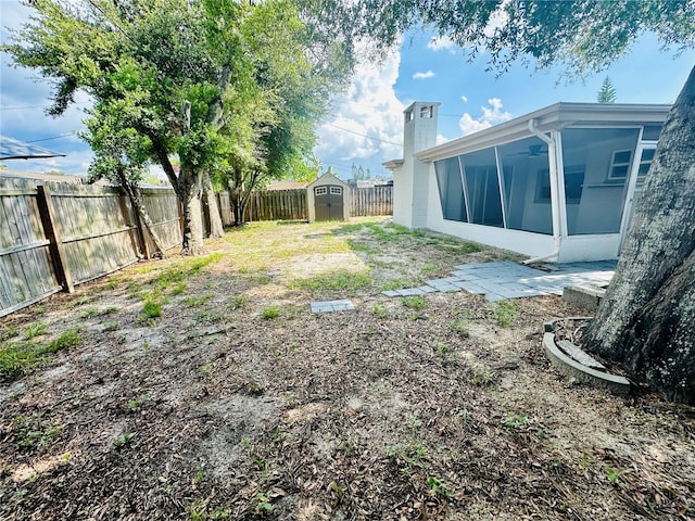 view of yard featuring a sunroom and a shed