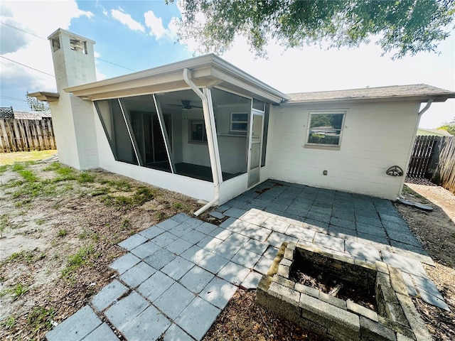 back of house featuring a patio area, a sunroom, and a fire pit