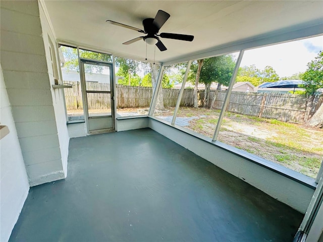 unfurnished sunroom with ceiling fan