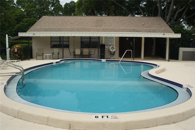 view of swimming pool with a bar and a patio