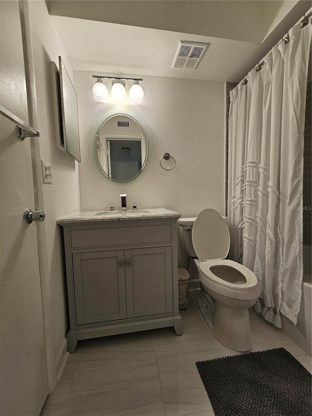 full bathroom with tile patterned floors, vanity, shower / bath combo with shower curtain, and toilet