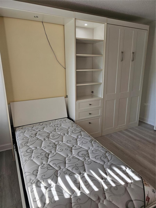 unfurnished bedroom featuring a textured ceiling and dark wood-type flooring