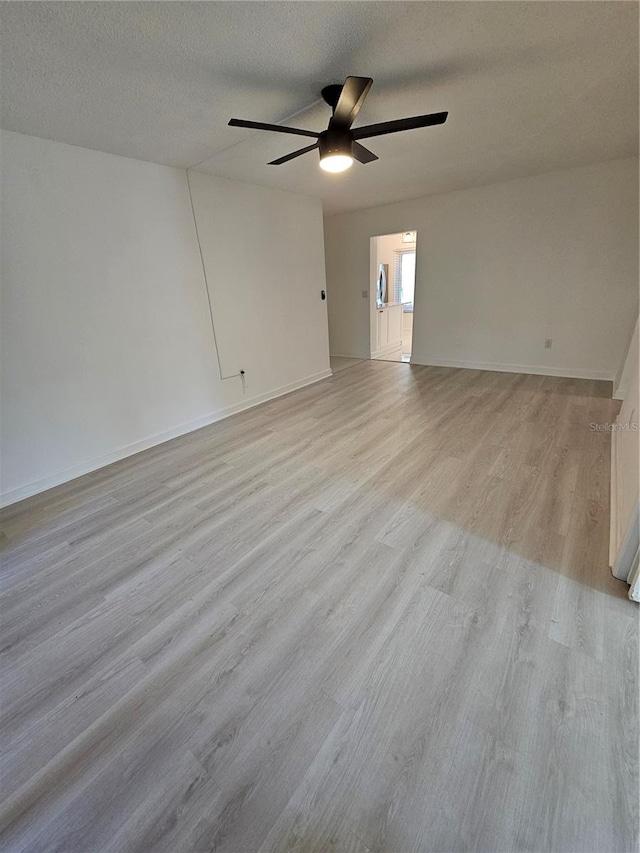 spare room with a textured ceiling, light hardwood / wood-style flooring, and ceiling fan