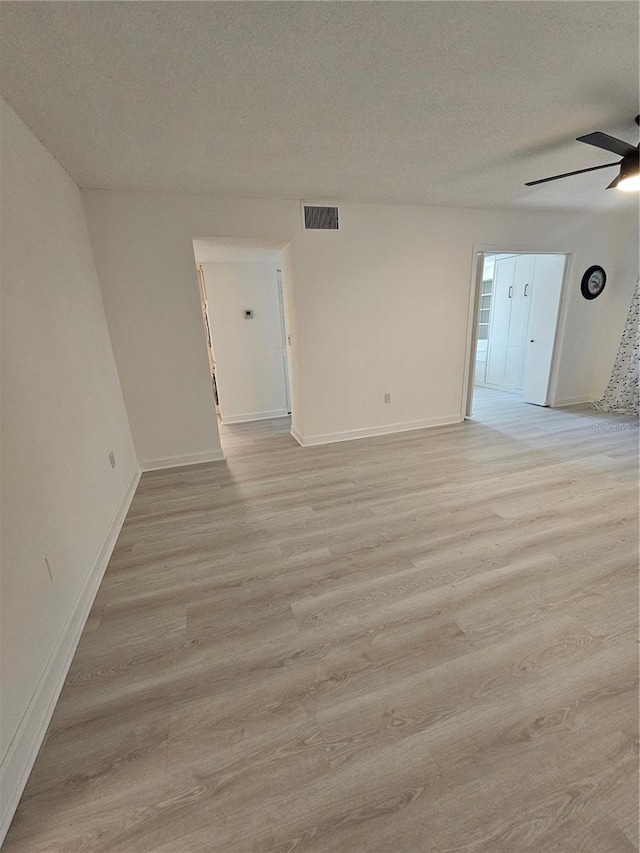 unfurnished room with light hardwood / wood-style flooring, a textured ceiling, and ceiling fan