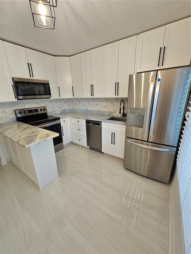 kitchen featuring light tile patterned flooring, stainless steel appliances, white cabinets, sink, and light stone counters