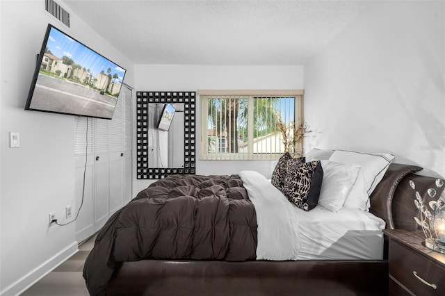 2207 Belleair Rd Unit A32, Clearwater, FL 33764 - bedroom with a textured ceiling and wood finished floors