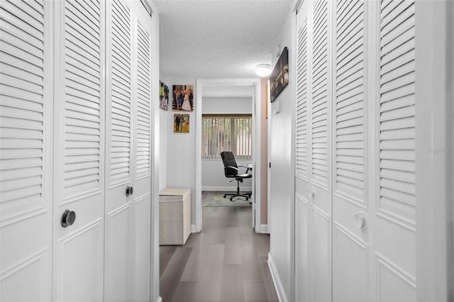 2207 Belleair Rd Unit A32, Clearwater, FL 33764 - corridor with a textured ceiling, dark wood-style floors, a desk, and baseboards