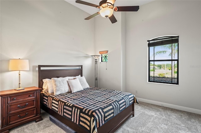 carpeted bedroom featuring ceiling fan and high vaulted ceiling